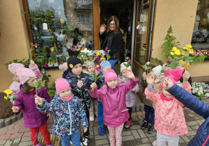zdjęcie grupowe z nauczycielką przed kwiaciarnią z panią kwiaciarką