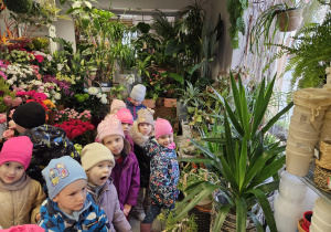 dzieci w kwiaciarni oglądają kwiaty cięte i domowe
