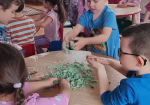 dzieci przygotowują magiczny piasek