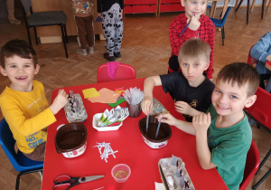 dzieci pipetami wlewają wodę do pojemników