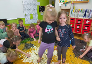 dzieci idą boso po ułożonym chrupkowym kurczaku