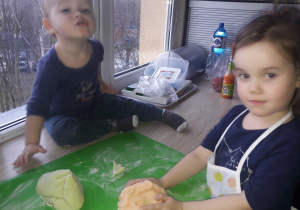rodzeństwo ugniata ciasto w kuchni