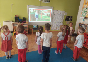 przedszkolaki stoją na baczność słuchając hymnu polskiego