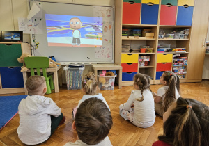 dzieci oglądają film edukacyjny o symbolach i barwach ojczystych