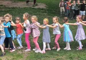 dzieci podczas zabawy w pociąg na terenie ogrodu pzredszkolnego