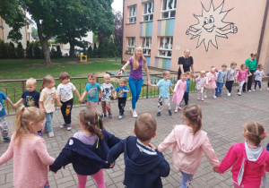 przedszkolaki podczas zabawy na tarasie przedszkolnym stoją w wielkim kole