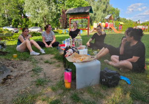 nauczycielki w przerwie w pracy, siedzą piknikując w ogrodzie