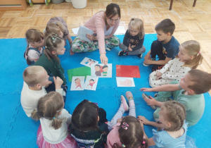pani Kasia pokazuje dzieciom obrazki a dzieci określają emocje jakie pokazują dzieci na obrazku