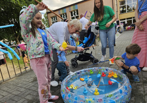 dzieci łowią na wędki ryby i kaczki w niebieskim basenie z wodą
