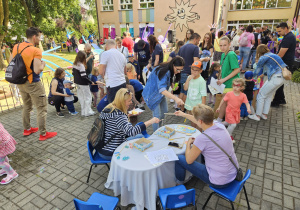 zabawy w łowienie rybek na magnez pzry stoliku przez dorosłych i dzieci w krainie niebieskiej