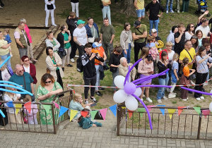widok z okna na ludzi oglądających dzieci podczas występu na tarasie przedszkolnym