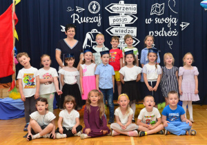 zdjęcie grupowe w biretach z nauczycielką - grupa V