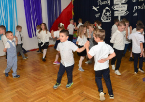 przedszkolaki tańczą w parach trzymając się lewymi rękami