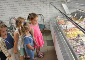 przedszkolaki w cukierni stoją przed ladą z lodami