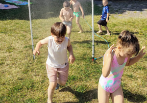 przedszkolaki przebiegają pod bramką z kurtyną wodną