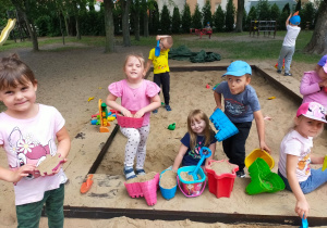 dzieci bawią się w piaskownicy w ogrodzie przedszkolnym