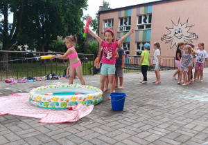 zawody sportowe ze strzelaniem wodą z pompki do celu na tarasie przedszkolnym