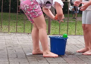 dziewczynka moczy gąbkę w wodzie