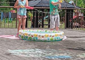 dzieci celują pompkami na wodę do celu