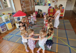 dzieci bawią się w pociąg, który prowadzi pani