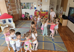 dzieci bawią się w pociąg, który prowadzi pani