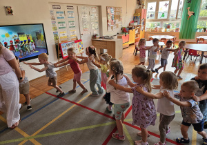 dzieci bawią się w pociąg, który prowadzi pani