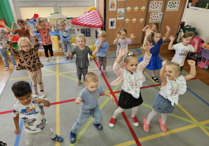 dzieci tańczą z uniesionymi rękami