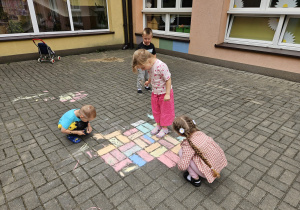 przedszkolaki rysują kredą na trasie przedszkolnym