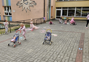 dzieci jeżdżą wózkami po tarasie przedszkolnym