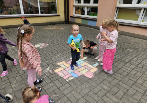 przedszkolaki rysują kredą na trasie przedszkolnym