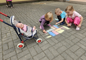 przedszkolaki rysują kredą na trasie przedszkolnym