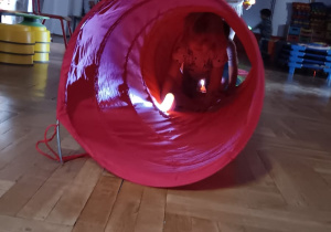 dzieci bawią się światłem - oświetlają sobie drogę w okrągłym tunelu