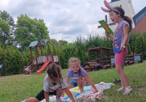 dziewczynki bawią się na macie w ogrodzie