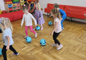 dzieci starają się lekko kopać piłkę