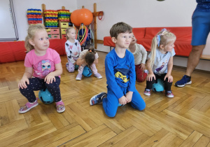 dzieci siedzą na piłkach w bezruchu