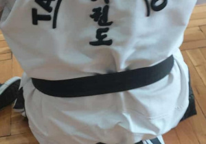 trener w kimonie z napisem taekwon-do siedzi tyłem