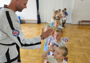 dzieci przybijają piątkę z trenerem