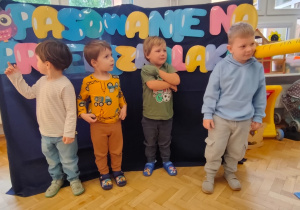 chłopiec jest pasowany na przedszkolaka, zostaje dotknięta wielką kredką w ramię
