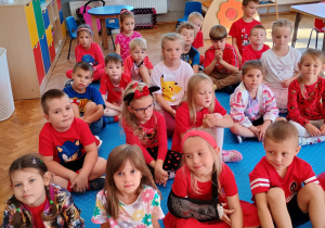 zdjęcie grupowe dzieci siedzących na macie w szeregach