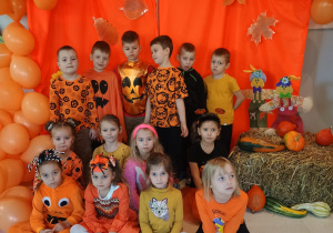 zdjęcie grupowe dzieci na tle pomarańczowej ścianki