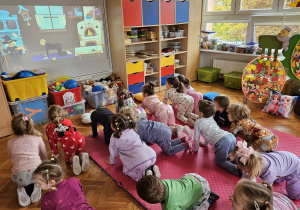 pani psycholog z dziećmi wykonuje ćwiczenie z jogi - kot