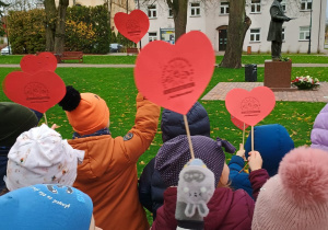 dzieci idą z serduszkami pod pomnik założyciela miasta Zduńskiej Woli