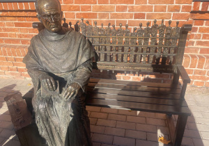 ławeczka z Marią Maksymilianem Kolbe przy dworcu kolejowym w Zduńskiej Woli
