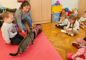 mama pokazuje dzieciom przenośny domek dla kota