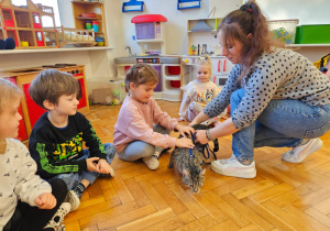 mama trzyma kota a dzieci głaszczą