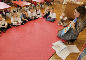 pani Kasia opowiada dzieciom siedzącym w kole oprawach dziecka