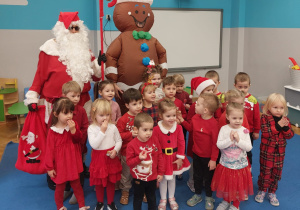 zdjęcie grupowe przedszkolaków z grupy VIII z Mikołajem i Piernikowym Ludzikiem oraz nauczycielką