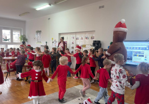 przedszkolaki idą wężykiem po sali z Piernikowym Ludzikiem