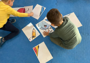 chłopcy podczas układania puzzli z kredkami