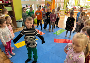 przedszkolaki stoją przy ułożonych puzzlach z kredkami